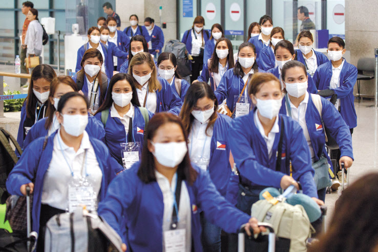 외국인 가사관리사 시범사업에 참여하는 필리핀 가사관리사들이 6일 아침 인천국제공항 제1터미널을 통해 입국한 뒤 버스로 이동하고 있다.[공항사진기자단]