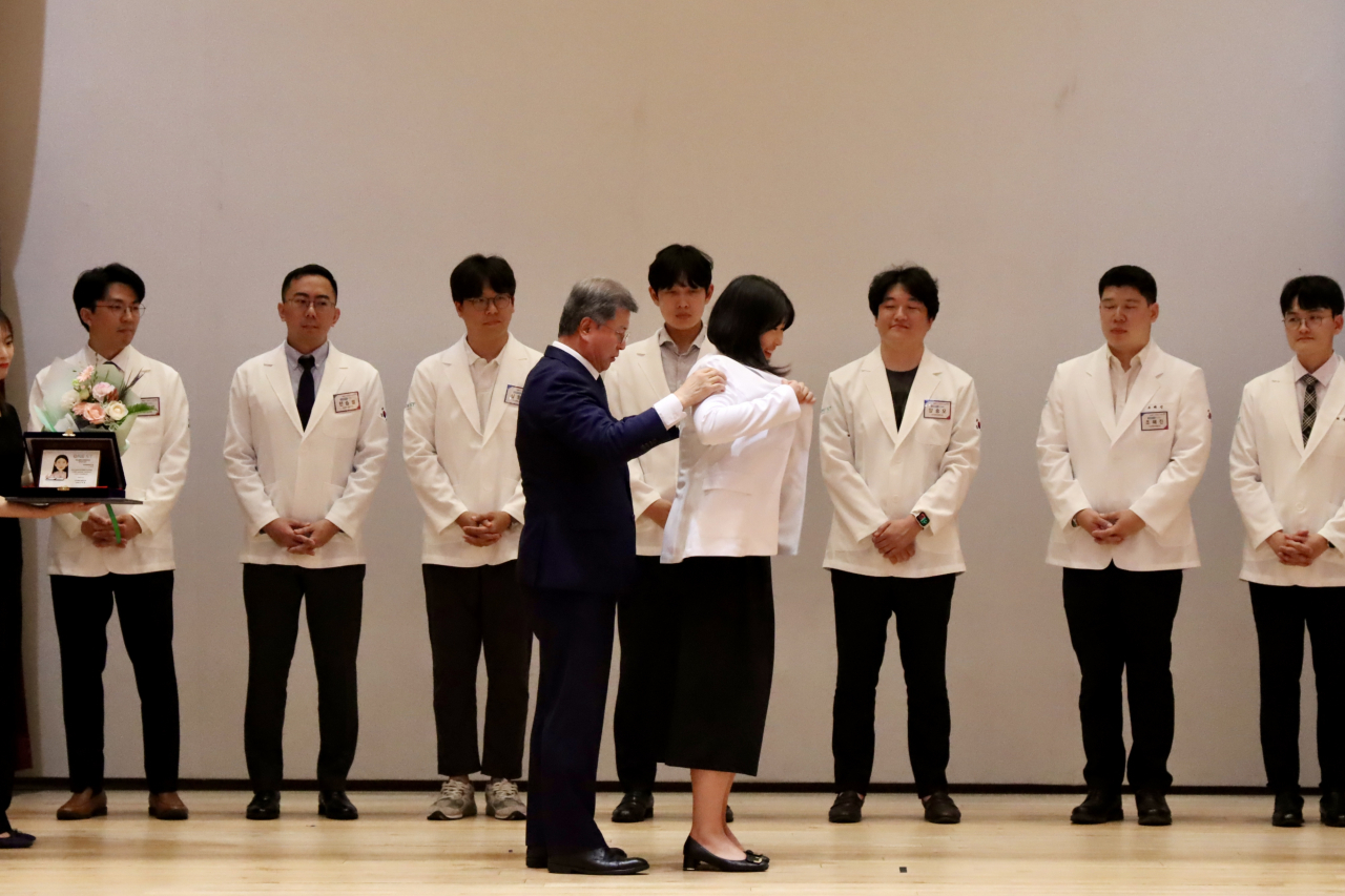 김복철 이사장이 연구창조 분야 최우수상 수상자 이정미 박사에게 연구자 가운을 입혀주고 있다.[국가과학기술연구회 제공]