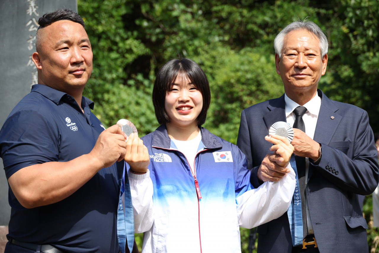 2024 파리 올림픽 유도 여자 57㎏급에서 은메달, 혼성 단체전에서 동메달을 딴 허미미(가운데)와 김정훈(왼쪽) 경북체육회 감독, 김점두 경북체육회장이 6일 오전 대구 군위군 삼국유사면 화수리에 조성된 독립운동가이자 허 선수의 현조부인 허석 지사의 기적비를 찾아 기념 촬영을 하고 있다. [연합]