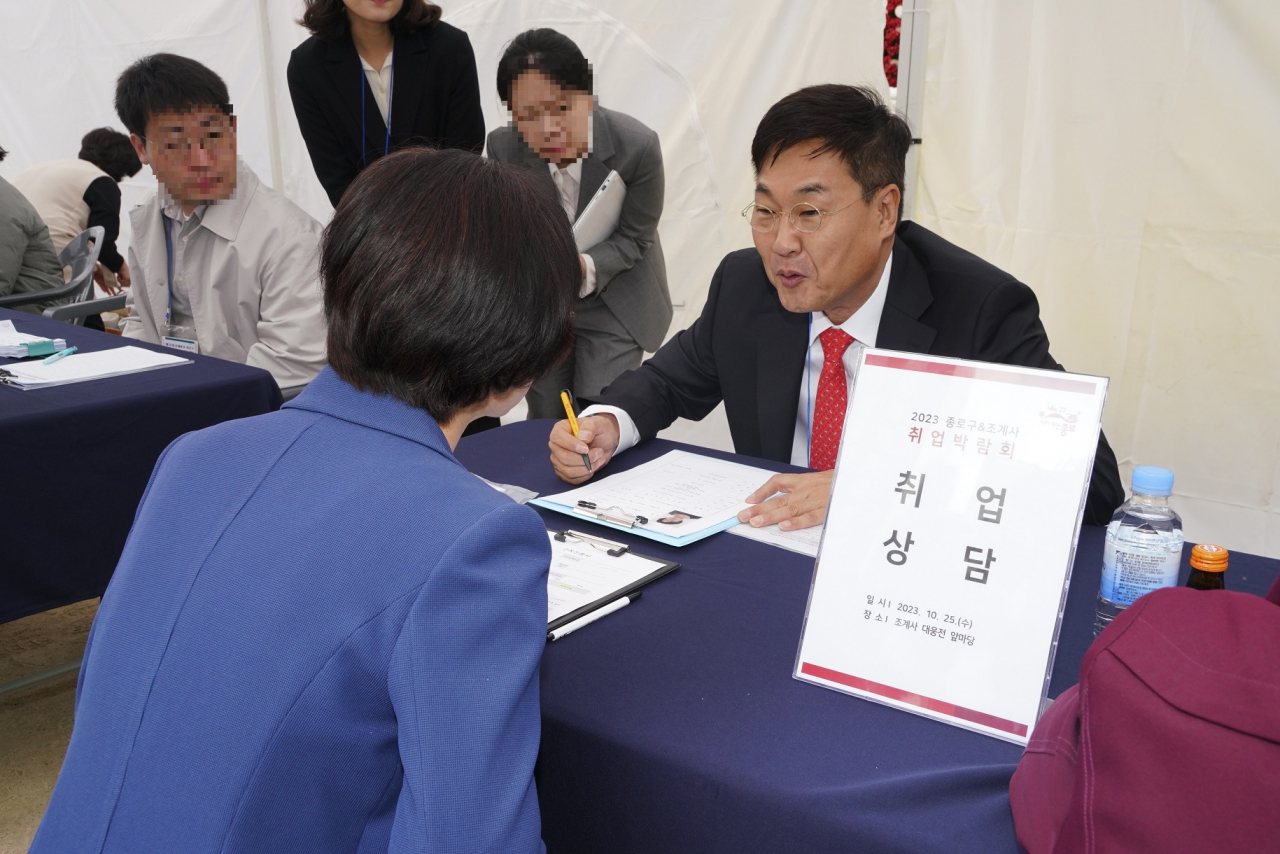 정문헌 종로구청장이 지난해 조계사에서 개최한 일자리 박람회에서 구직자와 이야기를 나누고 있다.[종로구 제공]