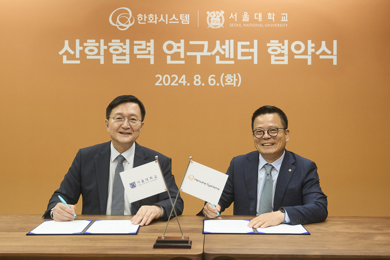 어성철(오른쪽) 한화시스템 대표이사, 유홍림 서울대 총장이 6일 ‘방위산업 및 ICT·AI 기반 우주 분야 산학 공동연구를 위한 업무협약(MOU)’을 체결하고 기념촬영을 하고 있다. [한화시스템 제공]