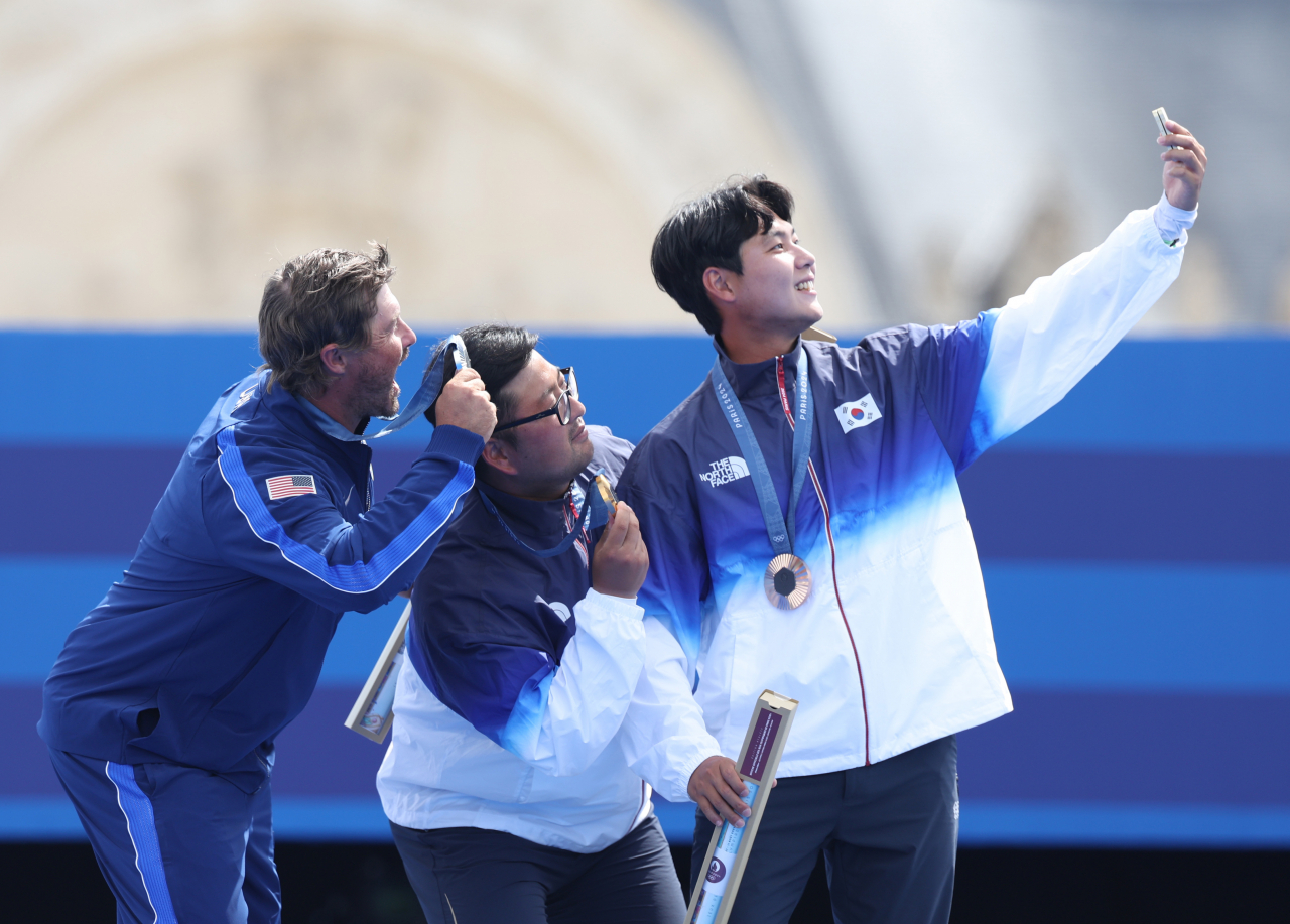 4일(현지시간) 프랑스 파리 레쟁발리드에서 열린 2024 파리올림픽 양궁 남자 개인전 시상식에서 한국 김우진(가운데)와 미국의 브레이디 엘리슨, 이우석이 셀카를 찍고 있다. 연합뉴스