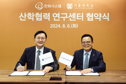 어성철(오른쪽) 한화시스템 대표이사와 유홍림 서울대 총장이 업무협약을 체결하고 기념촬영을 하고 있다. [한화시스템 제공]