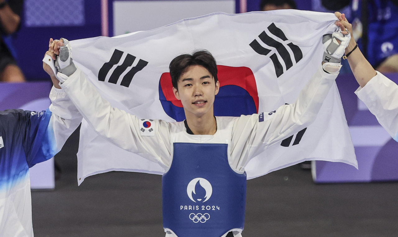 7일(현지시간) 프랑스 파리 그랑팔레 태권도경기장에서 열린 2024 파리올림픽 태권도 남자 58kg급 결승전에서 한국 박태준이 아제르바이잔의 가심 마고메도프에게 승리해 금메달을 따낸 뒤 태극기를 들고 기뻐하고 있다. [연합]
