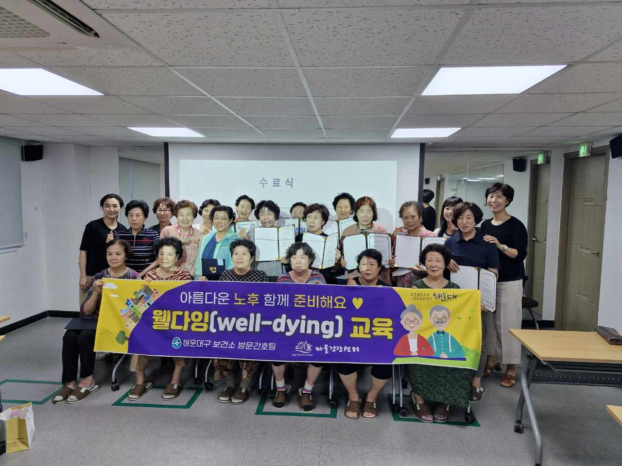 부산 해운대구보건소의 '아름다운 노후 함께 준비해요-웰다잉 교육' 수료생들이 기념촬영을 하고 있다. [사진=해운대구]