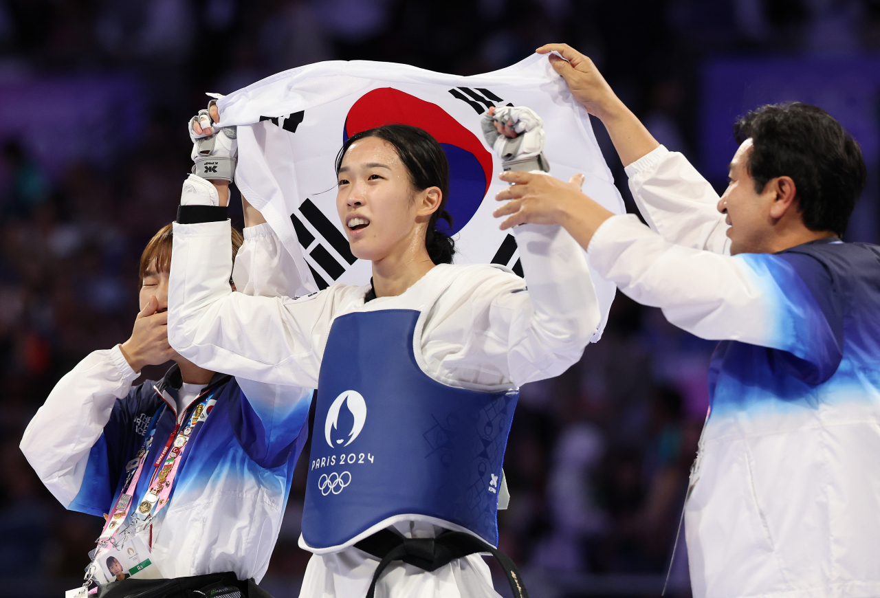 8일(현지시간) 프랑스 파리 그랑팔레 태권도경기장에서 열린 2024 파리 올림픽 태권도 여자 57㎏급 결승에서 이란의 나히드 키야니찬데에게 승리한 김유진이 태극기를 들고 세리머니를 하고 있다. [연합]