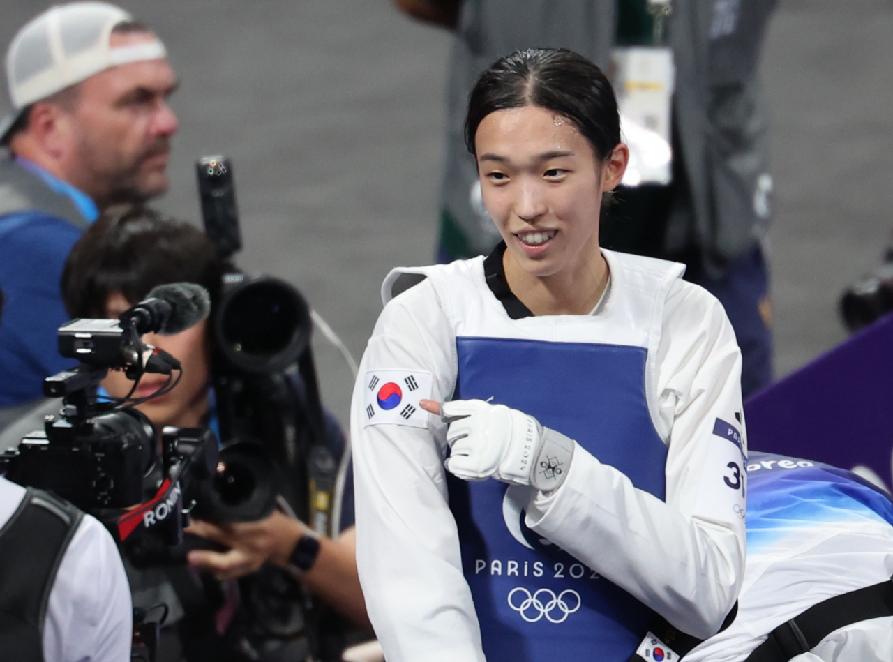 8일(현지시간) 프랑스 파리 그랑팔레 태권도경기장에서 열린 2024 파리 올림픽 태권도 여자 57㎏급 결승에서 한국의 김유진이 이란의 나히드 키야니찬데를 꺾고 금메달을 확정한 뒤 도복의 태극기를 가리키고 있다. [연합]