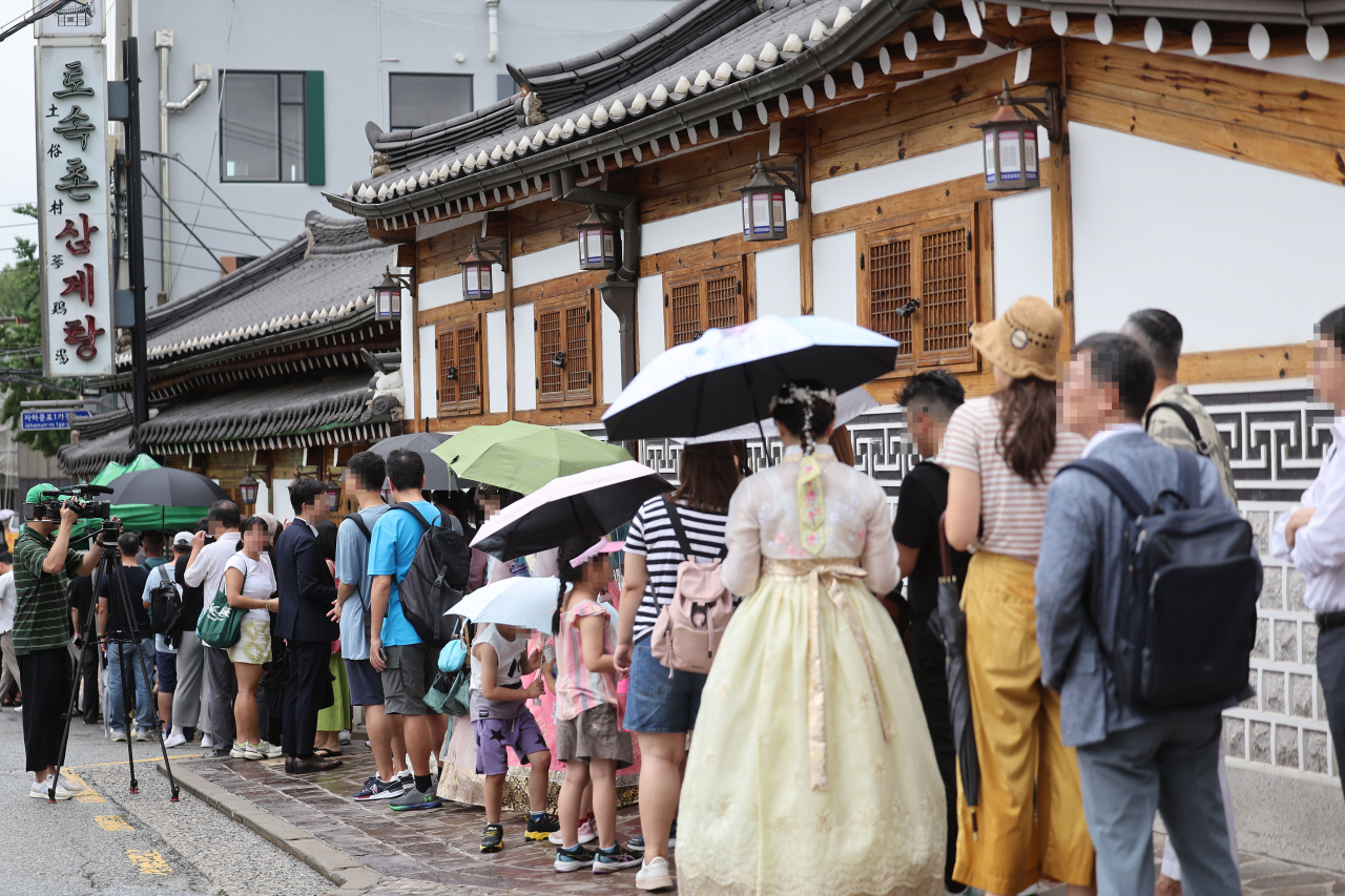 중복인 지난달 25일 서울 시내 한 삼계탕집 앞에서 시민들이 입장하기 위해 줄을 서 있다. [연합]