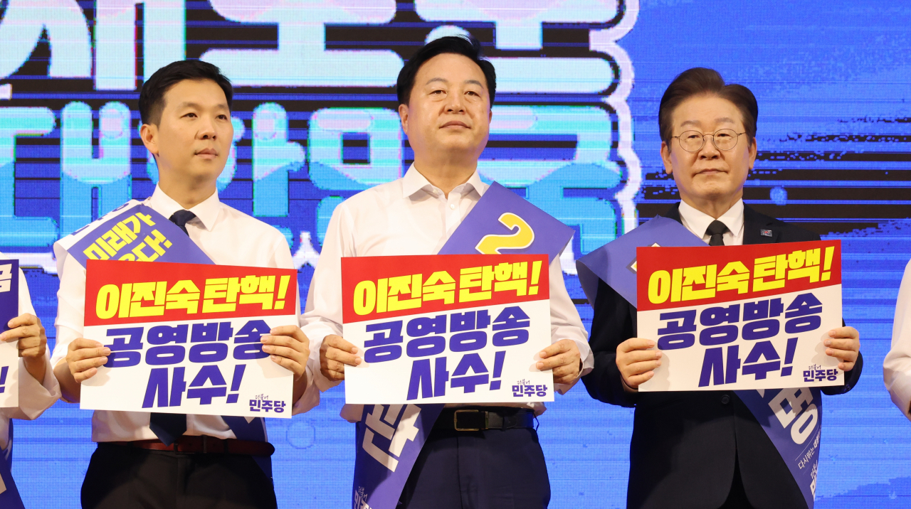 11일 대전 서구 배재대 스포렉스홀에서 열린 더불어민주당 당 대표·최고위원 후보자 합동연설회에서 김지수(왼쪽부터)·김두관·이재명 당 대표 후보가 단상에 서서 피켓을 들고 있다. [연합]