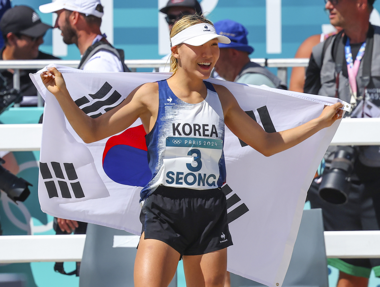 11일(현지시간) 프랑스 베르사유 궁전에서 열린 2024 파리 올림픽 근대5종 여자 결승전 레이저런에서 성승민이 동메달 질주를 마친 뒤 태극기를 두르고 활짝 웃고 있다. [연합]