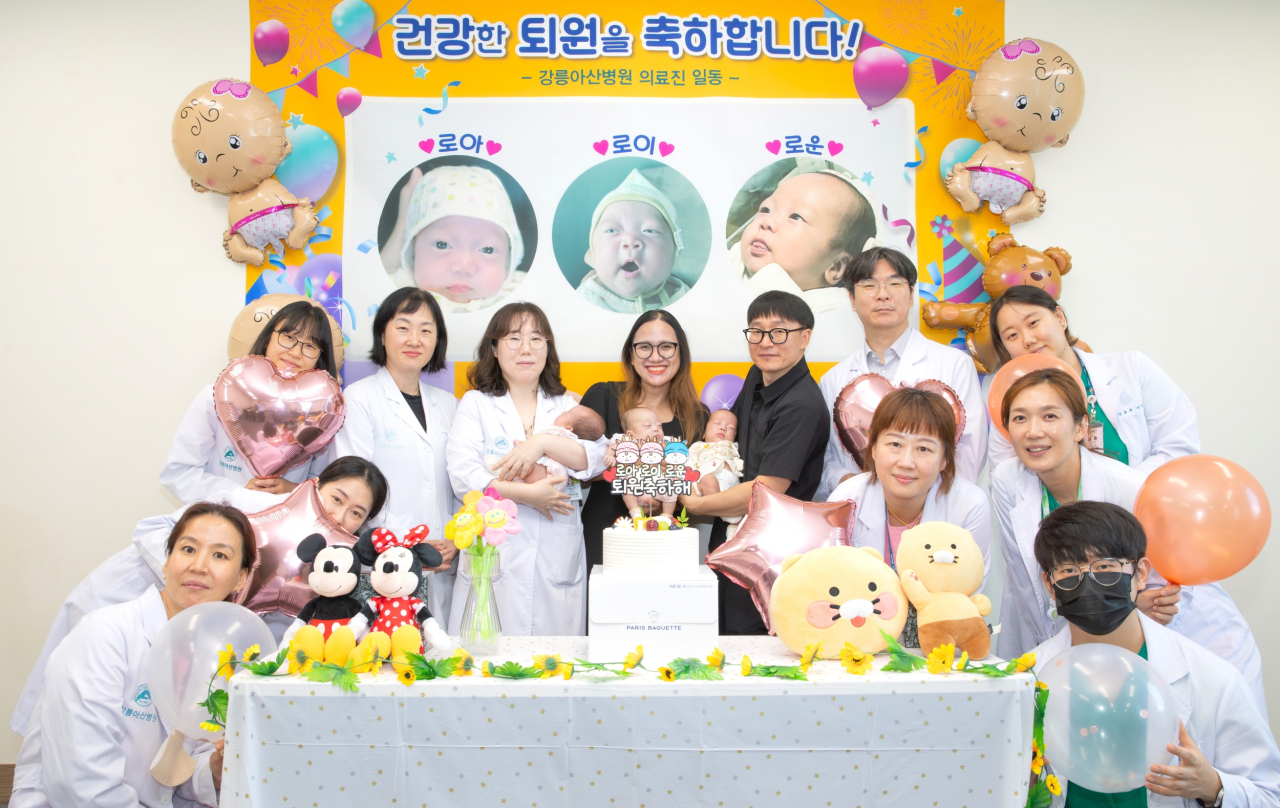 세쌍둥이 부모가 소아청소년과 진현승 교수, 도현정 교수, 산부인과 주다혜 교수, 신생아집중치료실 간호사들과 함께 퇴원을 축하하며 기념촬영을 하고 있다.[강릉아산병원 제공]