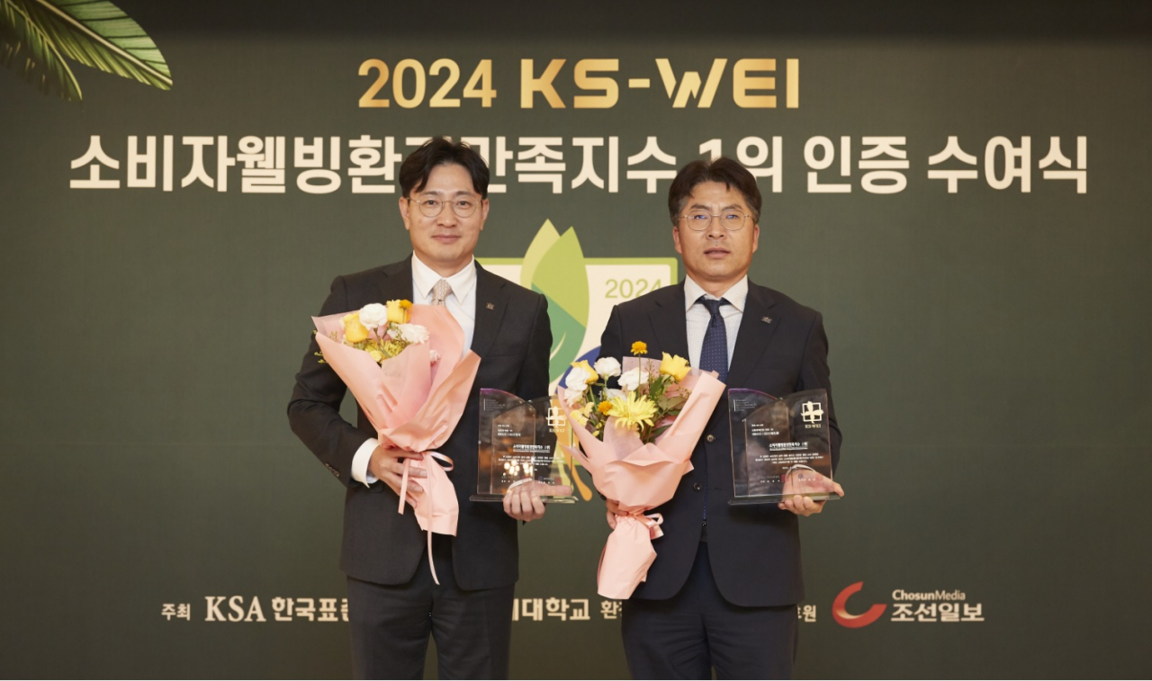 KCC 창호사업부 서호영(왼쪽) 상무와 유통도료사업부 함성수 상무가 소비자웰빙환경만족지수 1위 수상 이후 기념사진을 촬영하고 있다. [KCC 제공]