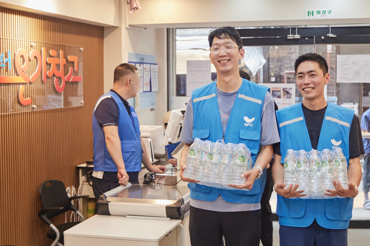 12일 서울 용산구 서울역쪽방상담소가 운영하는 나눔스토어 ‘온기창고’에서 SPC그룹 임직원들이 생수를 전달하고 있다. [SPC그룹 제공]