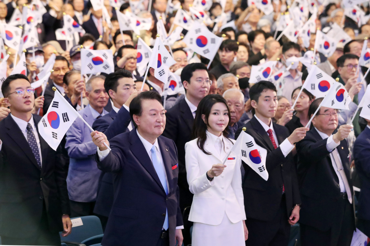 뉴라이트 논란 속 제79주년 광복절 경축식이 둘로 쪼개져 파행으로 치달을 가능성이 짙어지고 있다. 윤석열 대통령과 김건희 여사가 지난해 8월 15일 서울 서대문구 이화여대 대강당에서 열린 제78주년 광복절 경축식에서 만세삼창을 한 뒤 태극기를 흔들고 있다. [연합][연합]
