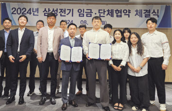 박봉수(앞줄 왼쪽 세 번째부터) 삼성전기 피플팀장(부사장)과 신훈식 존중노종조합지부장이 지난 12일 수원 컨벤션센터에서 열린 ‘2024년 임금협약 체결식’에서 기념촬영을 하고 있다. [삼성전기 제공]