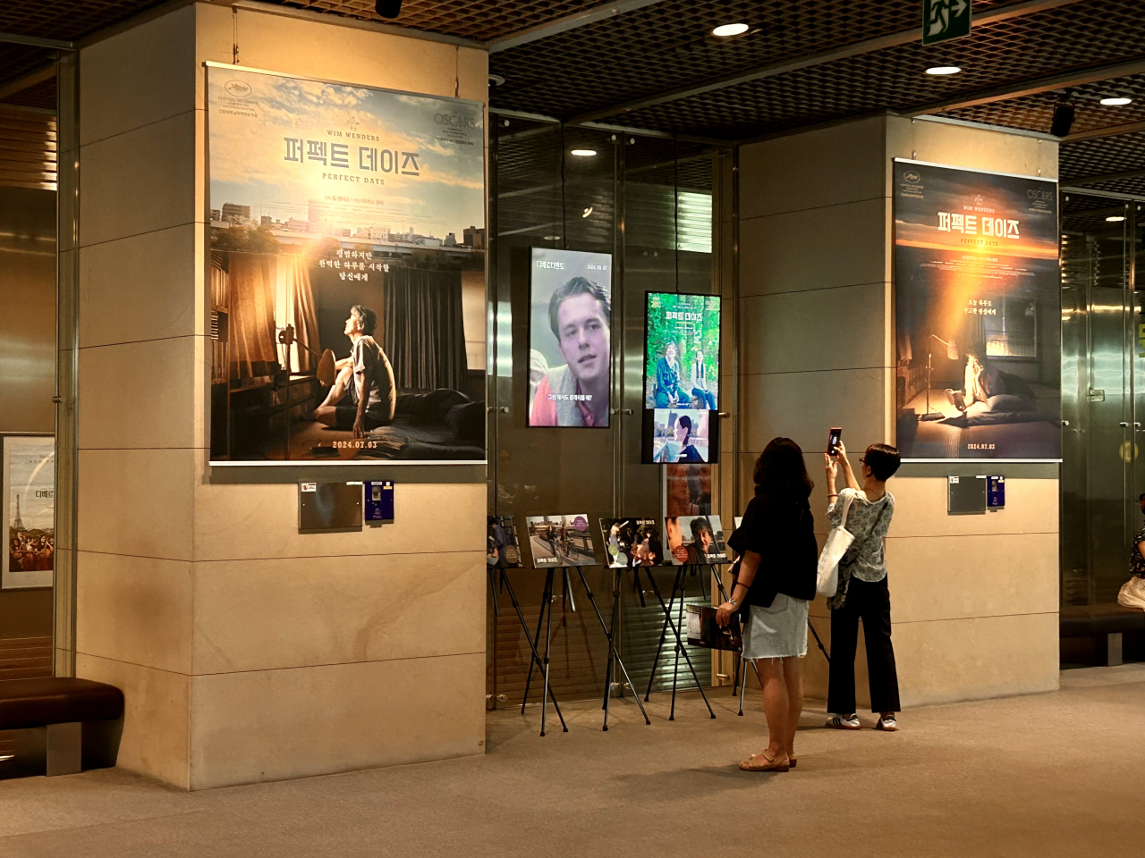 지난 8일 찾은 씨네큐브에서 관객들이 영화 ‘퍼펙트 데이즈’의 포스터를 살펴보고 있다. [김은희 기자]