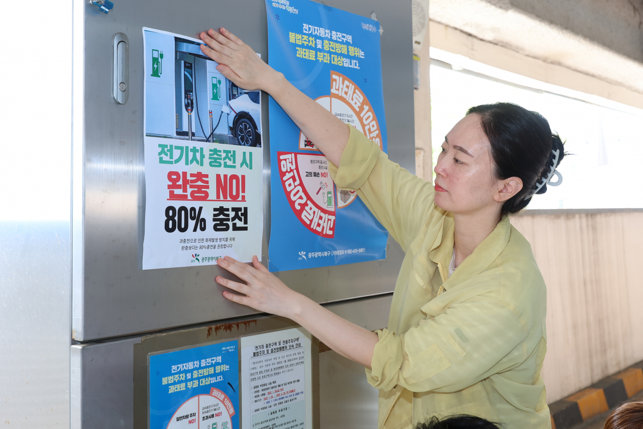 13일 오전 광주 북구 효죽1공영주차장에서 북구청 공직자들이 전기차 화재 예방을 위한 안전 수칙 홍보물을 부착하고 있다. 연합뉴스