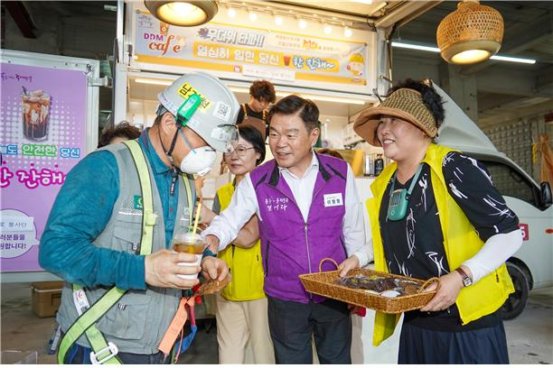 이필형 구청장이 동대문구 자원봉사단체 바로봉사단과 함께 장안동 씨젠 의료재단 서울본원 사옥 건립 현장에서 근로자 250여명에게 음료를 전달하고 있다.[동대문구 제공]