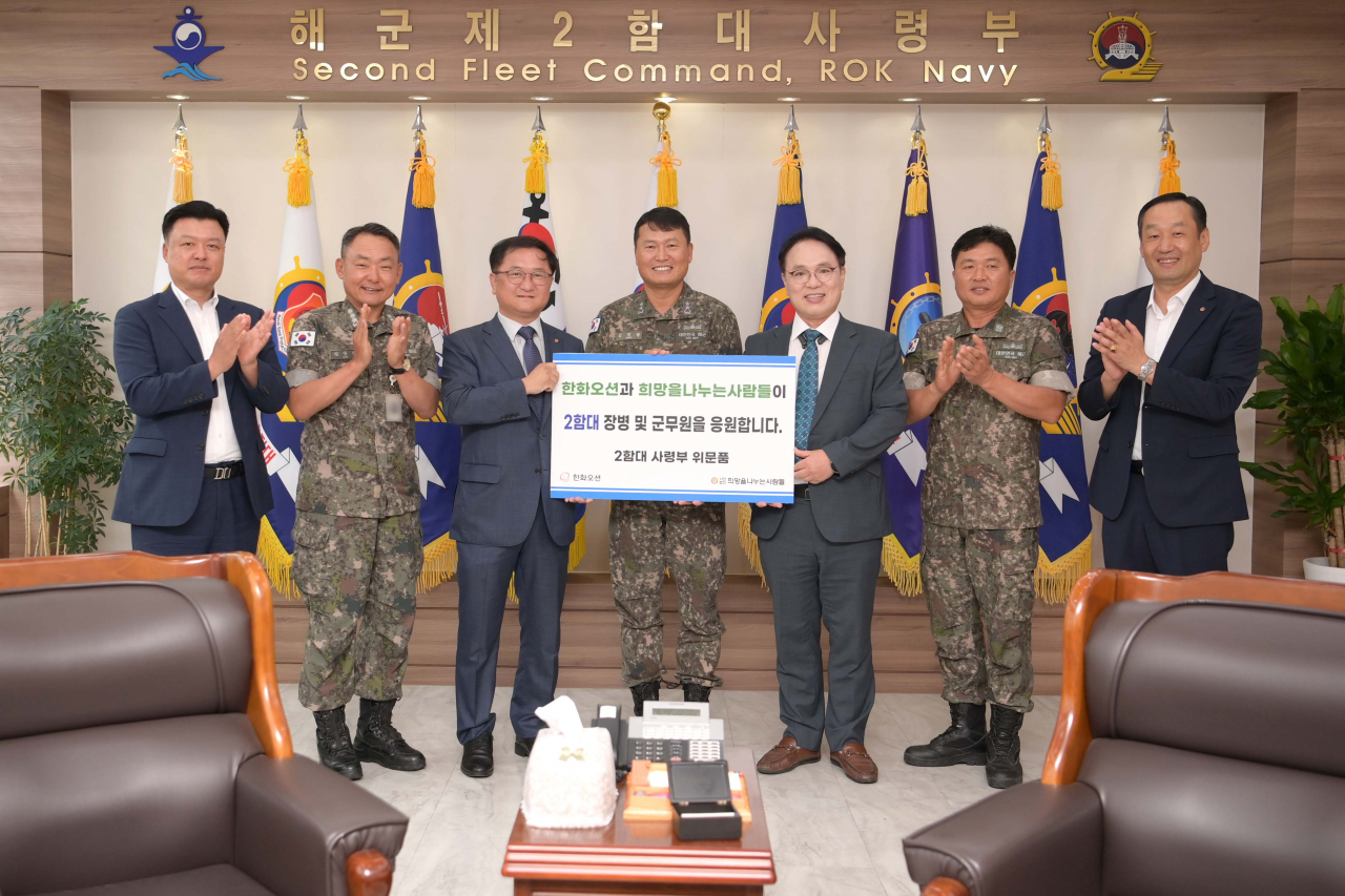 김호중(왼쪽 세 번째부터) 한화오션 특수선영업담당 상무와 김경철 해군 제2함대 사령관 소장, 김동우 ㈔희망을 나누는 사람들 부회장 등이 지난 12일 경기도 평택 해군 제2함대사령부에서 기념촬영을 하고 있다. [한화오션 제공]