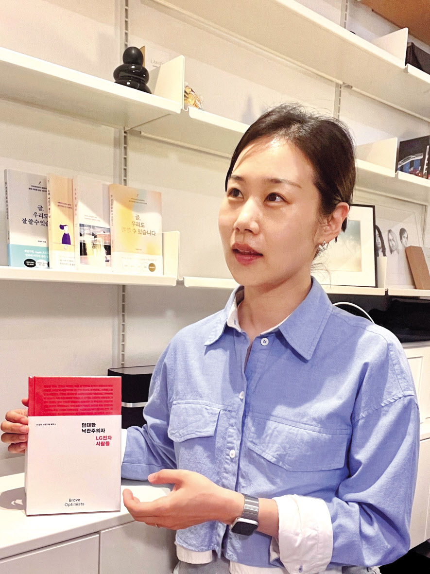 박솔미 LG전자 글로벌마케팅센터 브랜드전략팀 책임이 서울 여의도 LG트윈타워에서 진행된 헤럴드경제와의 인터뷰에서 직접 집필한 브랜드북 ‘담대한 낙관주의자, LG전자 사람들’을 소개하고 있다. [LG전자 제공]