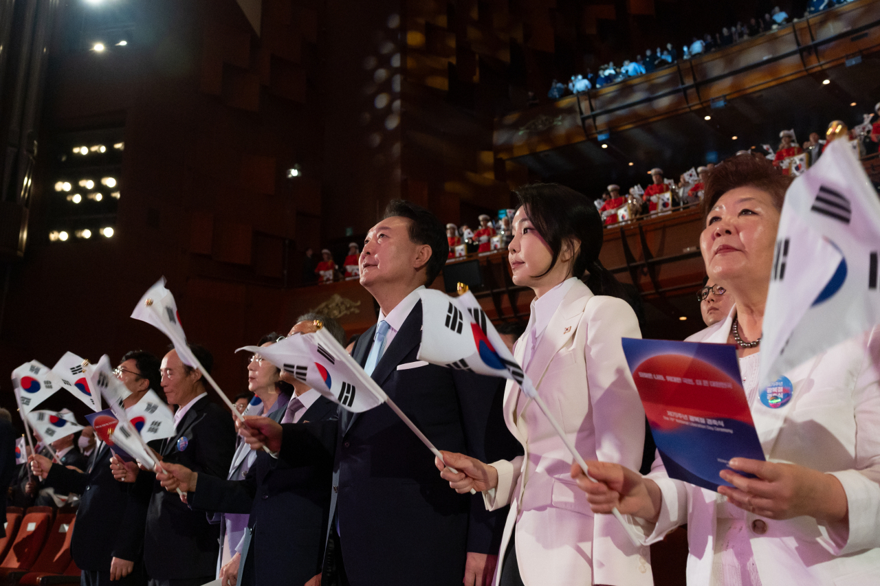 윤석열 대통령과 김건희 여사가 15일 서울 종로구 세종문화회관에서 열린 제79주년 광복절 경축식에서 태극기를 흔들고 있다. [연합]