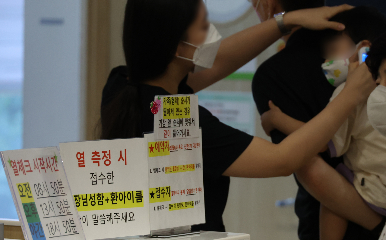 13일 오전 성북구 성북우리아이들병원이 의료진이 체온을 재고 있다. 대한아동병원협회에 따르면 코로나19 아동 환자는 7월 4주차 387명에서 8월 1주차 1080명으로 2.79배 늘었다. [연합]