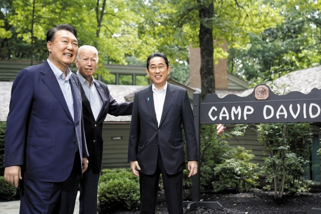 South Korean President Yoon Suk Yeol, US President Joe Biden, and Japanese Prime Minister Fumio Kishida (from left to right) are seen smiling broadly as they meet at the US presidential retreat, Camp David, on Aug. 18, 2023. (Yonhap)