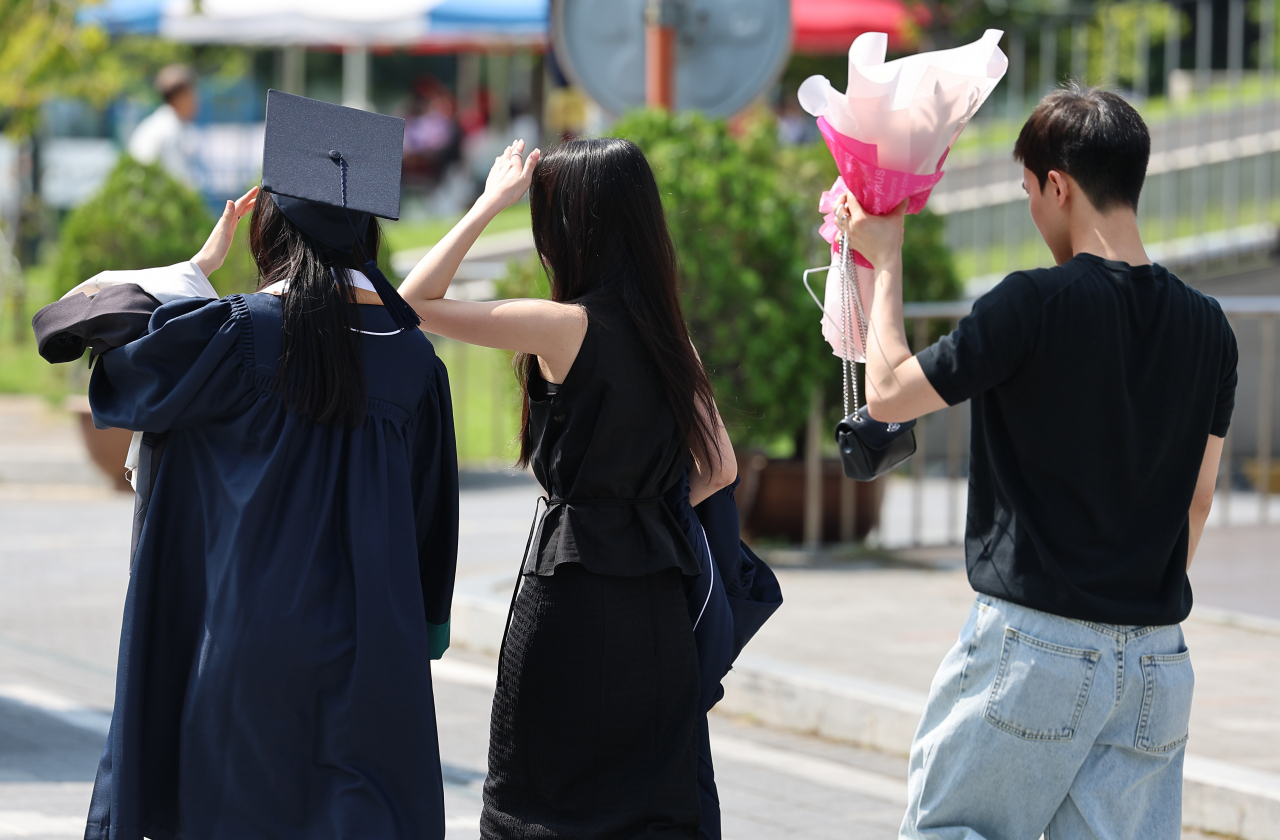 서울 동대문구 한국외국어대학교에서 졸업생 등이 손과 꽃다발로 햇빛을 가리고 있다. [연합]