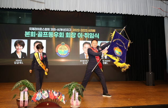 2022-2023 사자회 오시영 신임회장(오른쪽)이 김금옥 창립회장으로부터 사자회 기를 인계받아 흔들고 있다. [사진=22-23 사자회]
