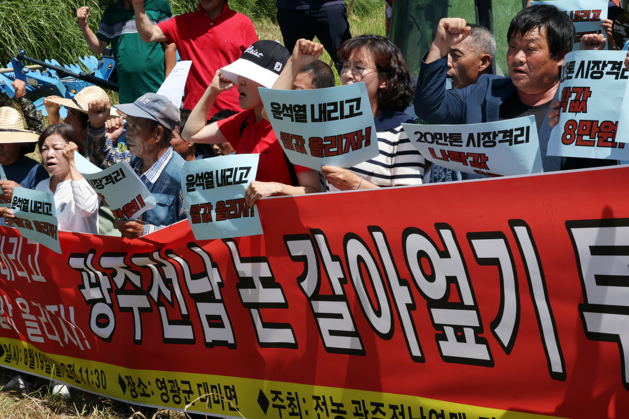 19일 오전 전남 영광군 대마면의 한 논 앞에서 농민회 광주전남연맹 회원들이 기자회견을 열어 정부에 쌀값 폭락 대책을 요구하는 구호를 외치고 있다. [연합]