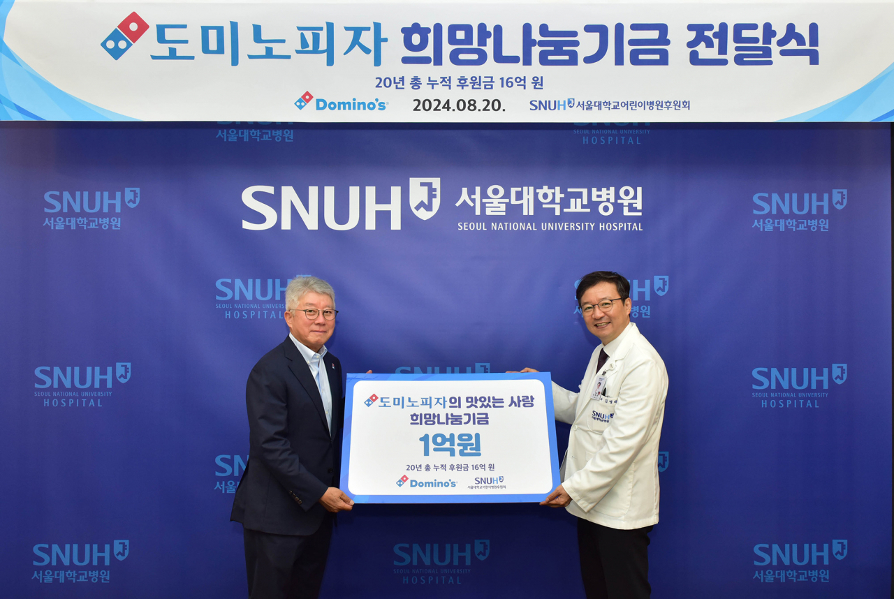 오광현(왼쪽) 도미노피자 회장과 김영태 서울대학교병원 병원장이 기부금 전달식에서 기념 사진 촬영을 하고 있다. [도미노피자 제공]