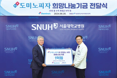 오광현(왼쪽) 도미노피자 회장과 김영태 서울대학교병원 병원장이 기부금 전달식에서 기념촬영을 하고 있다. [도미노피자 제공]