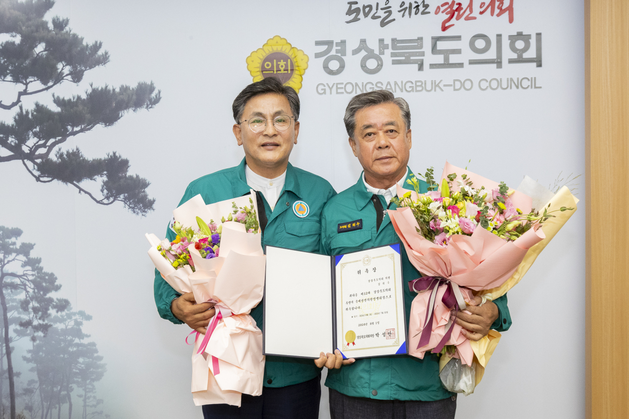 박성만 경북도의회 의장이 국제친선의원연맹 회장으로 위촉된 김희수 의원(오른쪽)에게 위촉장과 꽃다발을 전달하고 있다.[경북도의회 제공]