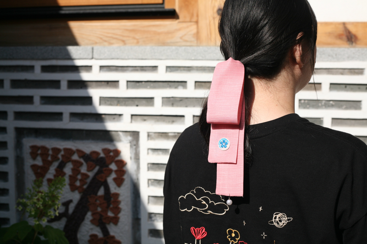 A visitor wears a Korean traditional hair ribbon called a "daenggi" made at Donuimun Museum Village. (Donuimun Museum Village)