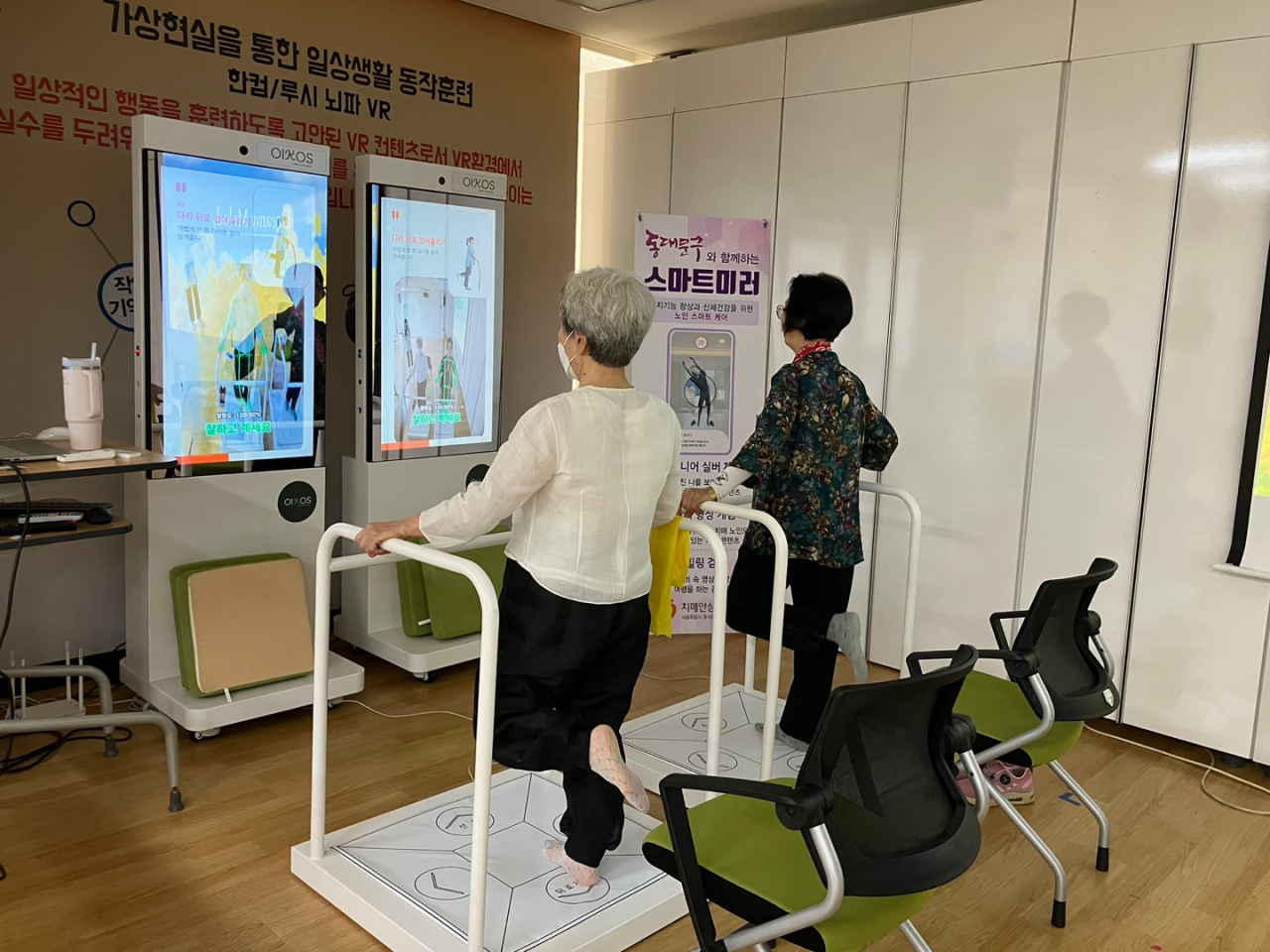 어르신들이 동대문구치매안심센터에 설치된 스마트미러를 활용해 운동 치료를 받고 있다.[동대문구 제공]