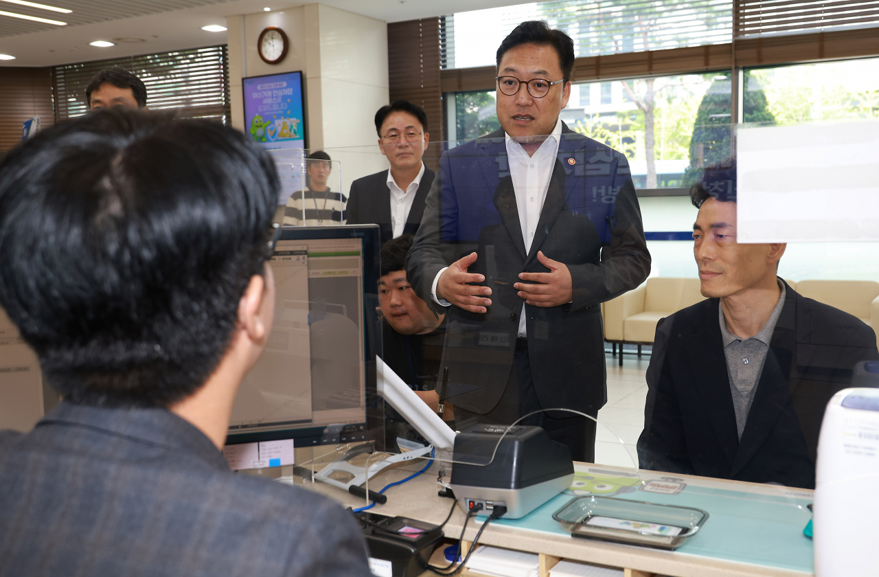김병환 금융위원회장이 23일 오전 서울 충정로 NH농협은행 본점에 방문해 창구 직원으로부터 여신거래 안심차단 서비스 가입 절차에 대해 듣고 직원들의 노고를 격려하고 있다. [금융위원회 제공]