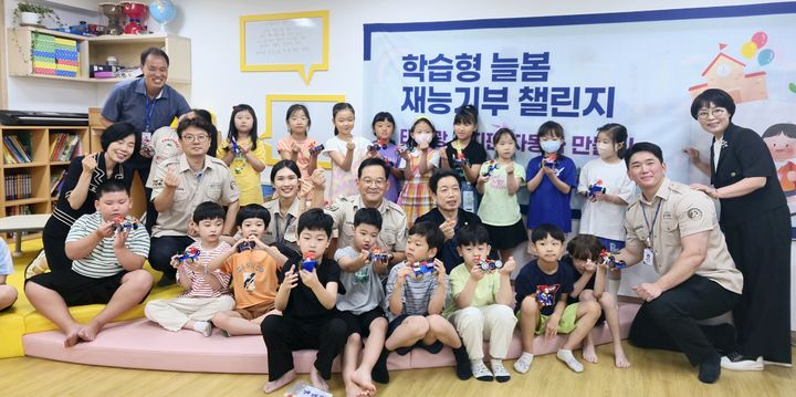 장석영 금양 부회장(둘째 줄 가운데 검은색 상의)과 재능기부팀이 23일 부산형 늘봄학교 재능기부 챌린지에 동참해 늘봄교실 학생들과 기념촬영을 하고 있다. [사진=금양]