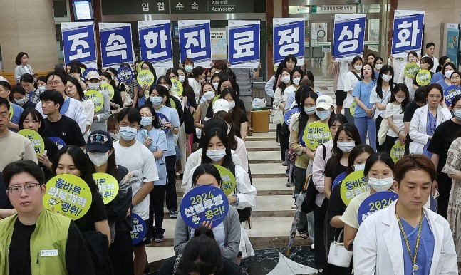 Doctors and medical workers hold a protest calling for the government to accept the "right medical reform" measures at a hospital in Seoul on July 18. (Yonhap)