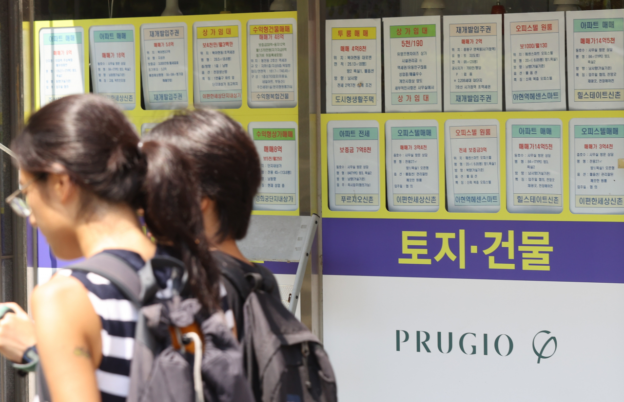 서울 한 부동산중개사무소 앞을 시민이 지나가고 있다.[연합]