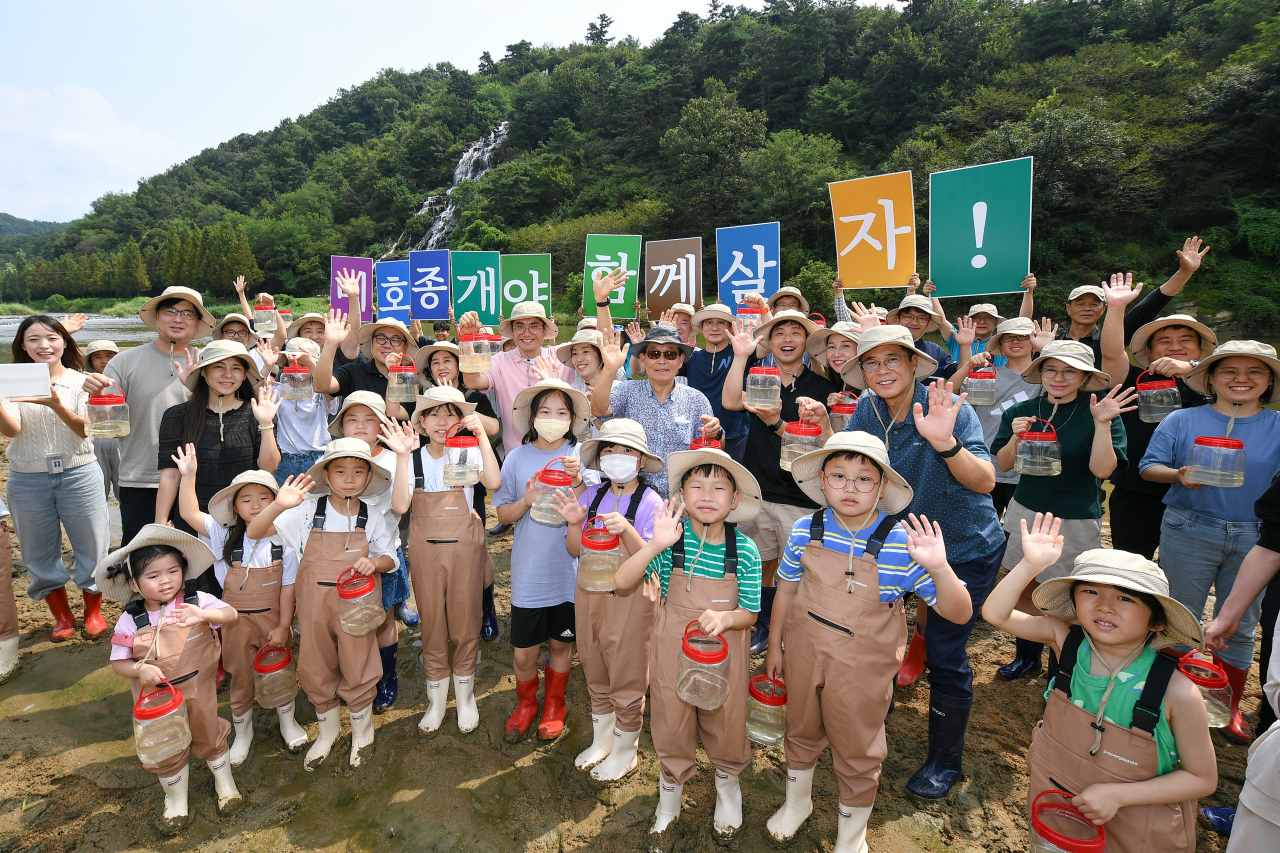 현대모비스가 멸종위기종 복원을 위해 지난 23일 미호종개 방류행사를 개최했다. 현대모비스 임직원과 가족, 지역주민들이 충북 진천군 초평면 미르숲 입구에서 미호종개를 방류하는 모습. [현대모비스 제공]
