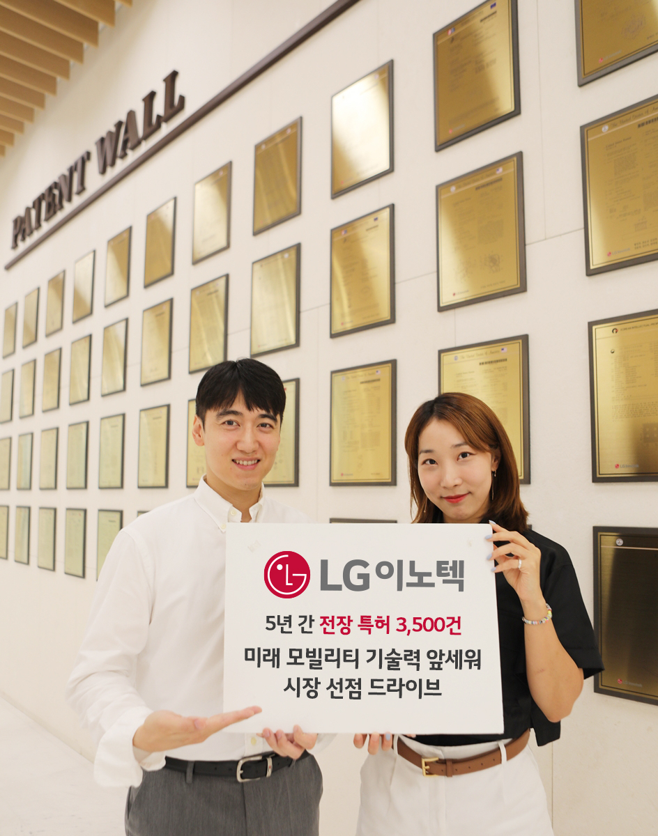 강서구 마곡사이언스파크 내 LG이노텍 본사 건물에 마련된 ‘페이턴트 월(Patent Wall)’ 앞에서 직원들이 전장 특허 성과를 소개하고 있다. ‘Patent Wall’은 LG이노텍이 확보한 주요 특허를 명판에 새겨 전시한 기념 공간이다. [LG이노텍 제공]