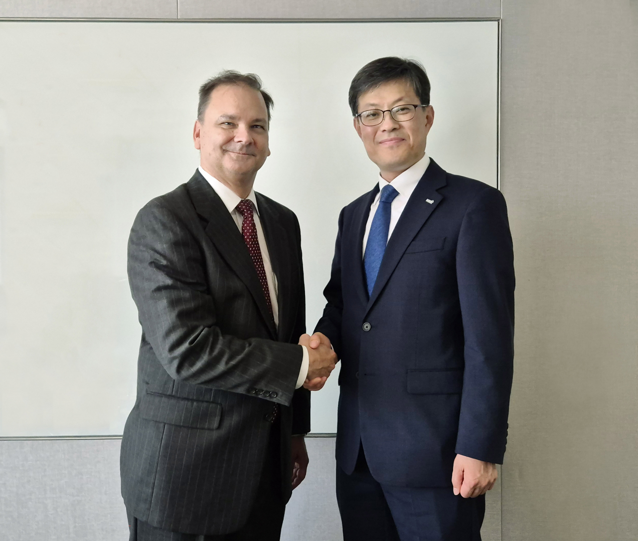김기경(오른쪽) 한국거래소 경영지원본부 부이사장과 릭 레딩 인덱스산업협회(IIA) 최고경영자(CEO)가 한국거래소의 IIA 회원 가입을 축하하는 자리에서 악수하고 있다. [한국거래소]