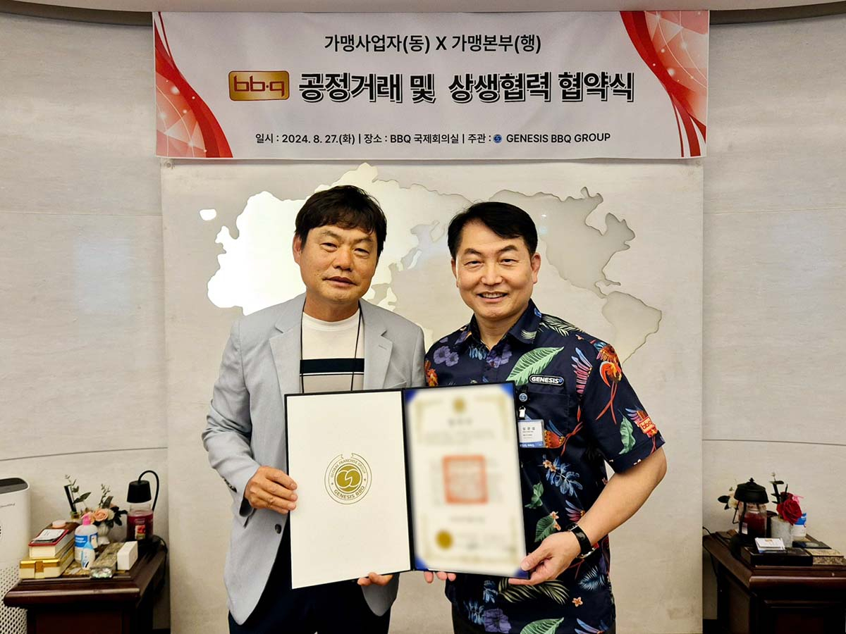 지난 27일 BBQ 본사 국제회의장에서 심관섭(오른쪽) 대표이사와 송교선 가맹점주가 협약 체결 기념 사진을 촬영하고 있다. [제너시스BBQ 그룹 제공]