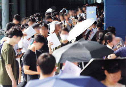 지난 22일 2025학년도 법학전문대학원 공동입학설명회가 열린 서울 서초구 aT센터 전시관 앞에 행사 시작을 기다리는 수험생들이 길게 줄지어 서 있다. [연합]