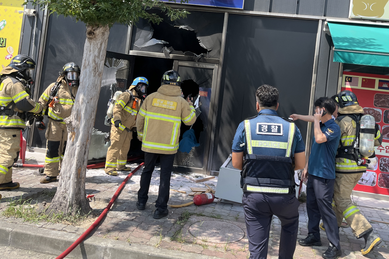 1일 오후 전남 영암군 삼호읍 한 상가건물 1층 성인게임장에서 방화로 인한 화재가 발생해 소방대원과 경찰관이 현장을 수습하고 있다. 이날 화재로 중국 국적인 60대 방화범 1명이 숨지고, 게임장 종업원과 손님 등 4명이 다쳤다. [연합]
