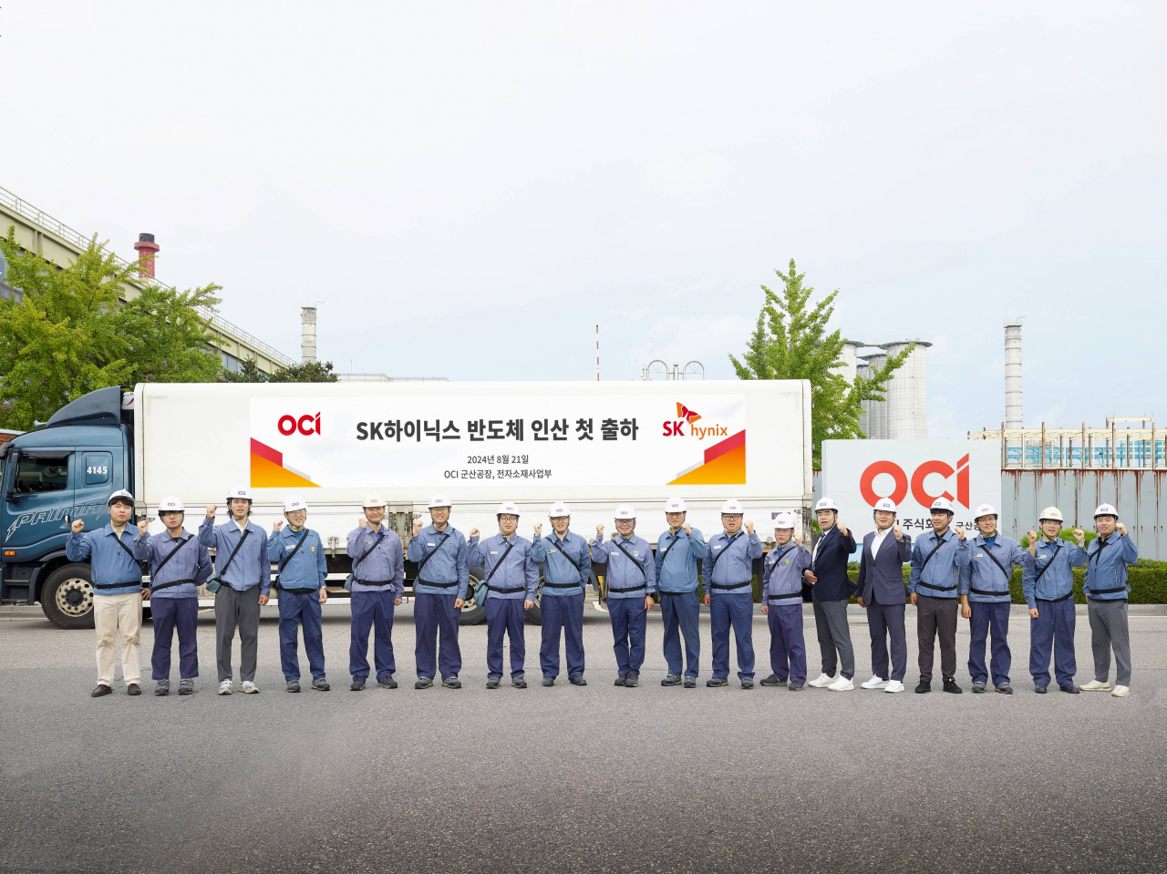 표상희(왼쪽 아홉 번째) OCI 군산공장장과 관계자들이 지난달 21일 SK하이닉스향 반도체 인산 첫 출하를 기념해 단체사진을 찍고 있다. [OCI 제공]