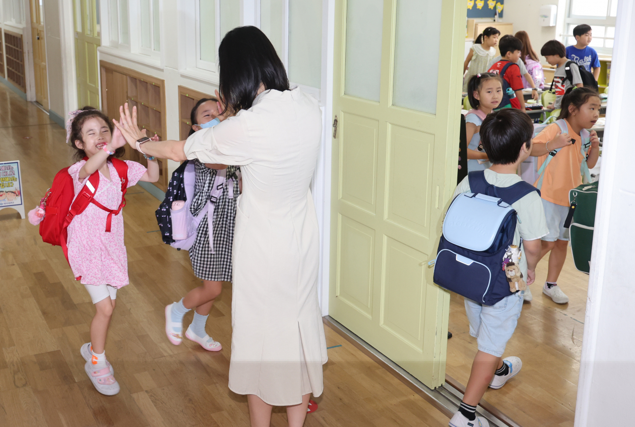 초등학교 교사를 양성하는 기관인 교육대학교와 대학 초등교육과에서 지난해 700명에 가까운 학생이 중도 탈락한 것으로 파악됐다. 사진은 8월 29일 오전 부산 북구 명덕초등학교 1학년 3반 교실에서 여름방학을 마치고 등교한 학생들이 선생님과 인사하고 있는 모습. [연합]