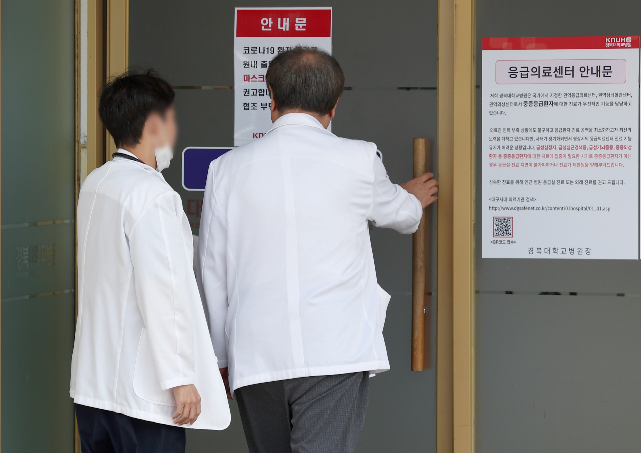 2일 대구 중구 경북대학교병원 응급실 앞에 코로나19 환자 증가 안내문과 중증응급환자 우선 진료 안내문이 붙은 가운데 의료관계자들이 응급실로 들어가고 있다. [연합]