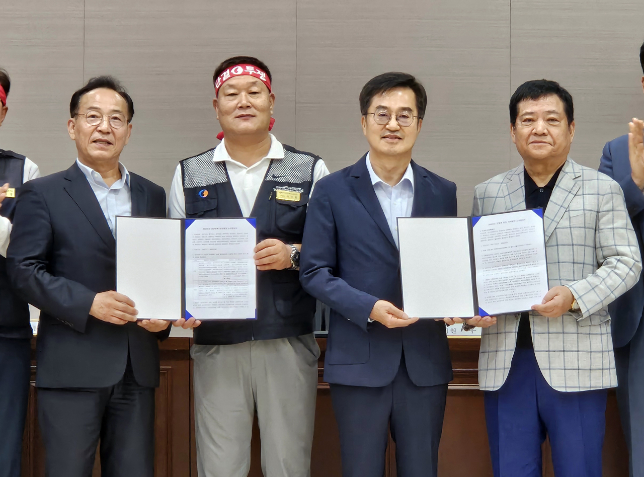 4일 오전 경기 수원시 경기지방노동위원회에서 경기도 버스 노사 관계자들이 합의문에 서명한 뒤 기념촬영을 하고 있다. 왼쪽부터 김태기 중앙노동위원회 위원장, 이기천 경기도버스노동조합협의회 의장, 김동연 경기도지사, 김기성 경기도버스운송사업조합 이사장. [연합]
