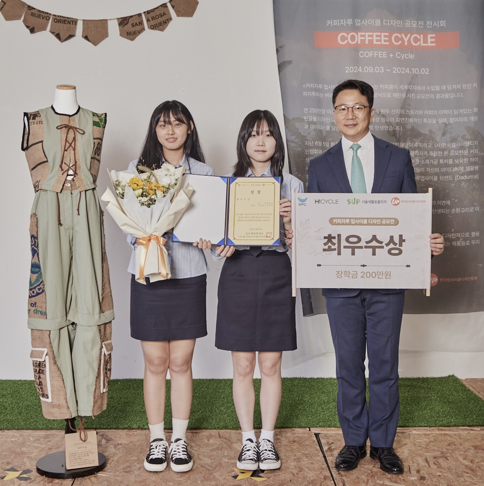 백승훈(오른쪽부터) SPC행복한재단 사무국장과 최우수상을 수상한 인천생활과학고등학교 양예주, 장아영 학생이 수상작 옆에서 기념촬영을 하고 있다. [SPC그룹 제공]
